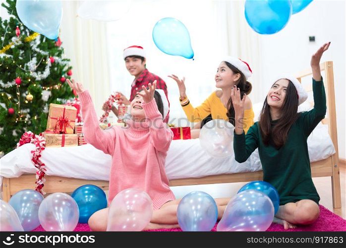 Group of Asian people are throwing the balloons for celebrating Christmas and New year. Holiday and party concept