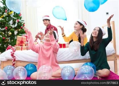 Group of Asian people are throwing the balloons for celebrating Christmas and New year. Holiday and party concept