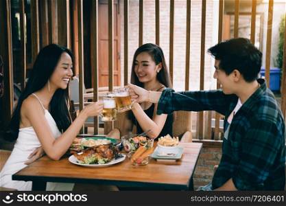 Group of asian people cheering beer at restaurant happy hour in restaurant.