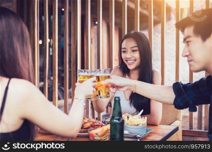 Group of asian people cheering beer at restaurant happy hour in restaurant.