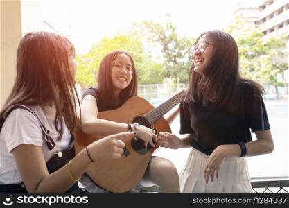 group of asian teenager happiness emotion playing spanish guitar on location