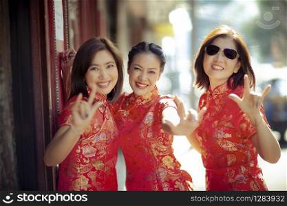group of asian woman wearing chinese tradition clothes toothy smiling face happiness emotion and hand sign i love you