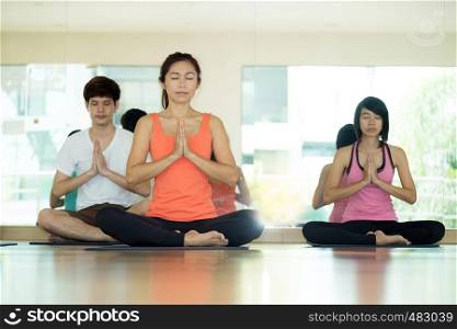 Group of asian women and man practicing yoga, fitness stretching flexibility pose, working out, healthy lifestyle, wellness, well being