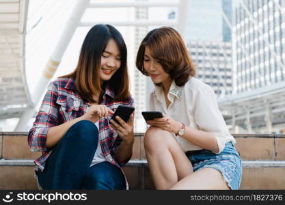 Group of Asian women using smartphone for direction and looking on location map while traveling in urban city in Bangkok, Thailand. Lifestyle tourist travel holiday in Thailand concept.