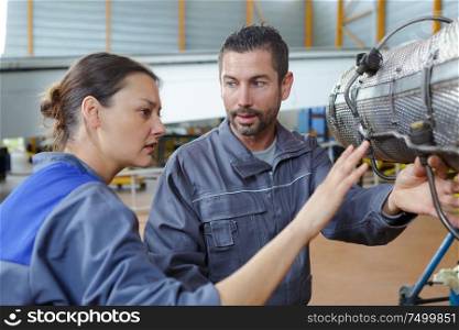group of assembler inspecting mechanical part