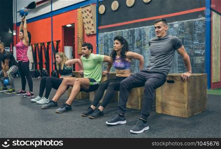 Group of athletes exercising doing box squats. Athletes exercising doing box squats