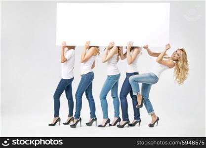 Group of attractive woman carrying empty board