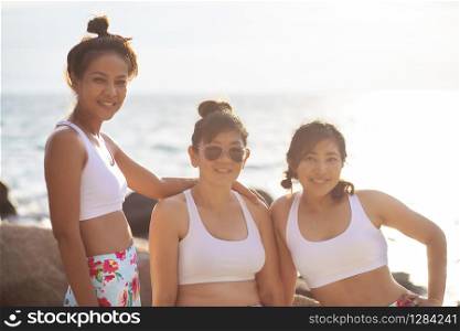 group of beautiful asian woman wearing sport suit relaxing with happiness emotion at sea side