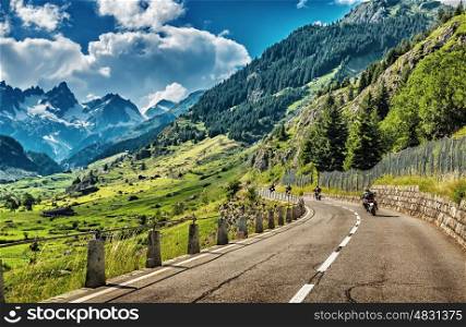 Group of bikers touring European Alps, motorcyclists on mountainous road, enjoying ride, summertime activities, wonderful mountain landscape, extreme activities, freedom vacation concept