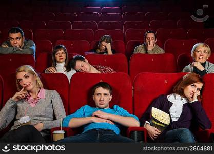 Group of boring people watching movie in cinema
