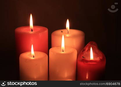 Group of burning candles in different heights and colors
