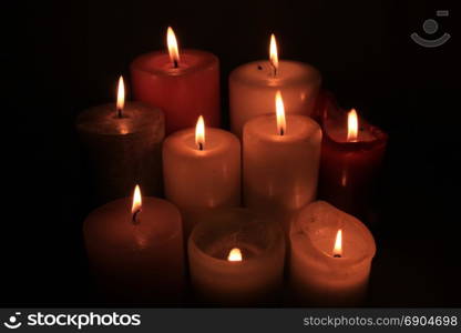 Group of burning candles in different heights and colors