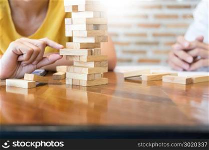Group of business creative people building tower by wooden blocks, doing a plan for brainstrom business strategy, risk, future, teamwork concept