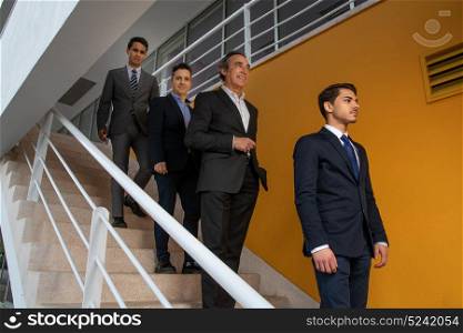 Group of Business man on the stairs with a yellow wall behind