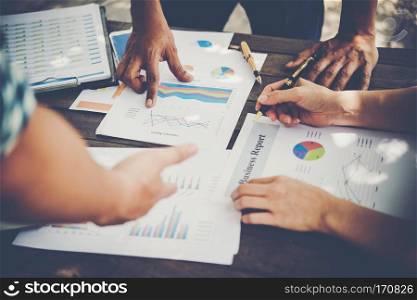 Group of business people analysis with marketing report graph, Young specialists are discussing business ideas for new digital start up project.. Group of business people analysis with marketing report graph, Y