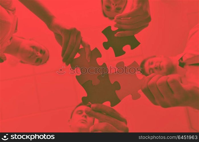 Group of business people assembling jigsaw puzzle and represent team support and help conceptduo tone