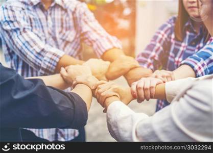 Group of business people crossed arms in pile for win. Stack of hands. Cooperation concept