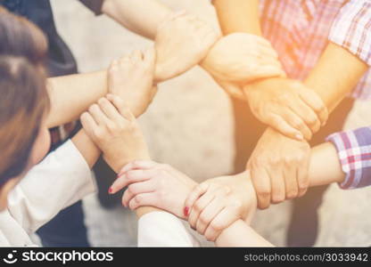 Group of business people crossed arms in pile for win. Stack of hands. Cooperation concept