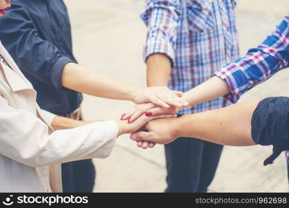 Group of business people crossed arms in pile for win. Stack of hands. Cooperation concept