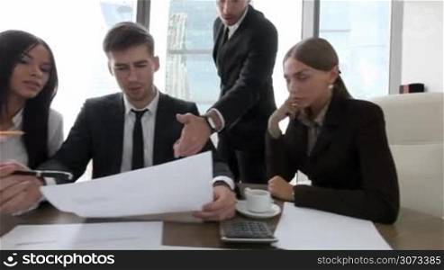 Group of business people discuss contract in office