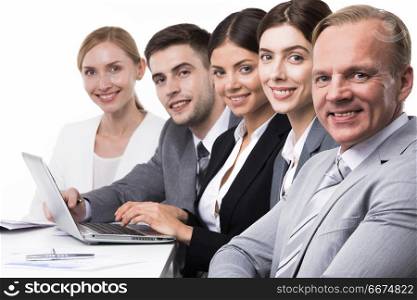 Group of business people. Group of confident smiling business people sitting together in a row with laptop, isolated on white background