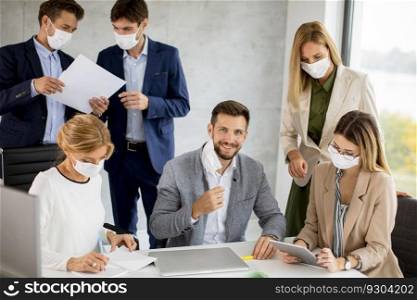 Group of business people have a meeting and working in the office and wear masks as protection from coronavirus