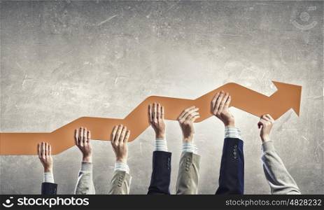 Group of business people holding growing graph in raised hands
