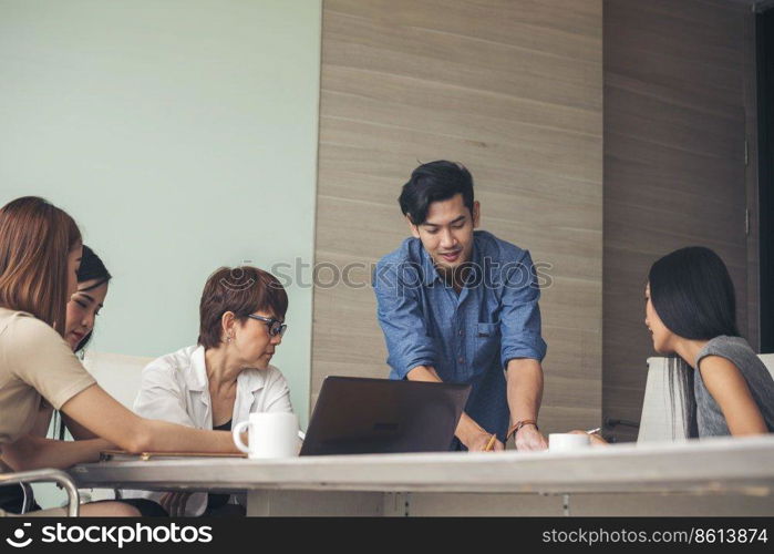 Group of business people meeting in conference room. Asian businessman speech, present teamwork partnership. Happy business people meeting present graph chart investment, business data in meeting room