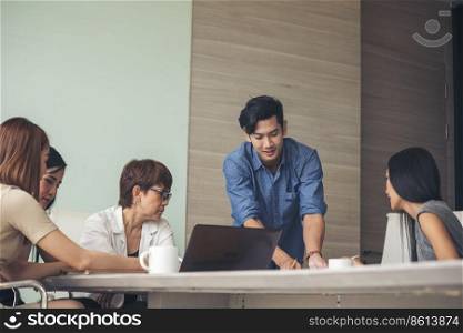Group of business people meeting in conference room. Asian businessman speech, present teamwork partnership. Happy business people meeting present graph chart investment, business data in meeting room