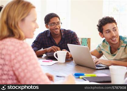 Group Of Business People Sitting Around Table In Meeting