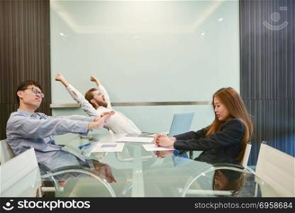 Group of business people stretching in meeting room with blank p. Group of business people stretching in meeting room with blank picture. Group of business people stretching in meeting room with blank picture