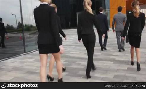 Group of business people walk outdoors office building