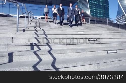 Group of business people walking down stairs outdoors
