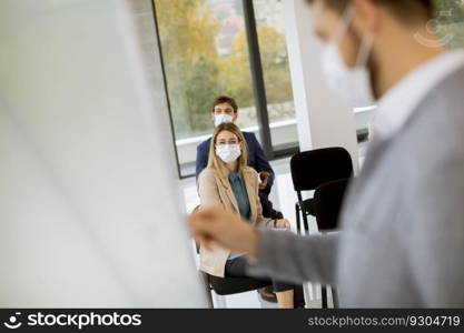 Group of business people with protective facial masks on education forum business seminar at corporate company