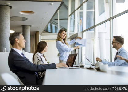 Group of business people with young adults and senior woman colleague on meeting at the modern bright office interior