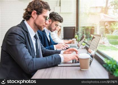 Group of business people working with modern laptops in office. Teamwork and Cooperation concept. Business worker and Salary man theme. Innovative and Technology theme