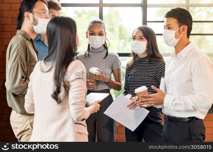 Group of business worker team meeting and brainstorm for startup new business. They wear protective face mask in new normal office preventing coronavirus COVID-19 spreading.