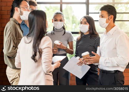 Group of business worker team meeting and brainstorm for startup new business. They wear protective face mask in new normal office preventing coronavirus COVID-19 spreading.