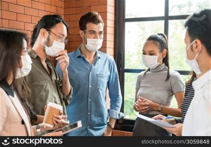 Group of business worker team meeting and brainstorm for startup new business. They wear protective face mask in new normal office preventing coronavirus COVID-19 spreading.