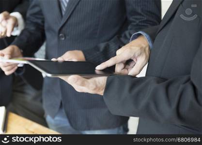 group of businessman meeting, analyzing and discussing with tablet and document