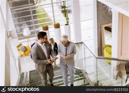 Group of businessmen and businesswomen walking and taking stairs in an office building