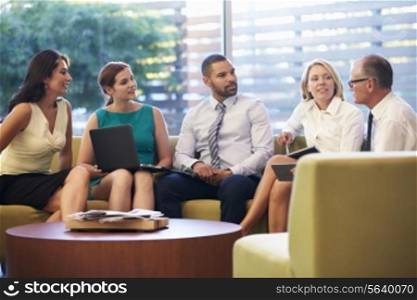 Group Of Businesspeople Having Meeting In Office Lobby