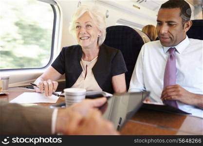 Group Of Businesspeople Having Meeting On Train