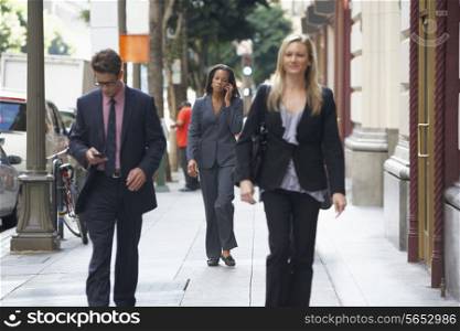 Group Of Businesspeople Walking Along Street