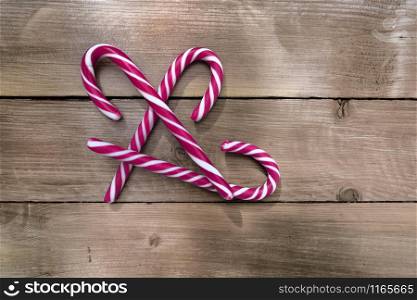 group of candy canes on a rustic wooden planks background