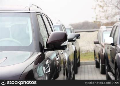 Group of cars stand in one number of dark color