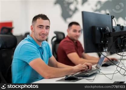 Group of Casual businessmen working on a desktop computer in modern open plan startup office interior. Selective focus. High-quality photo. Group of Casual business man working on desktop computer in modern open plan startup office interior. Selective focus 