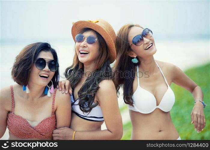 group of cheerful asian younger woman wearing beach bikini laughing with happiness emotion