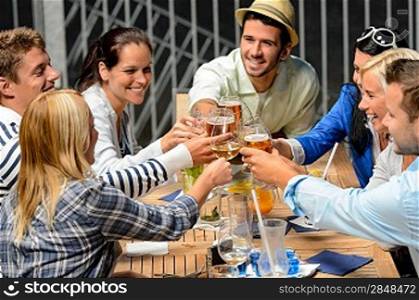 Group of cheerful young people toasting with drinks night out