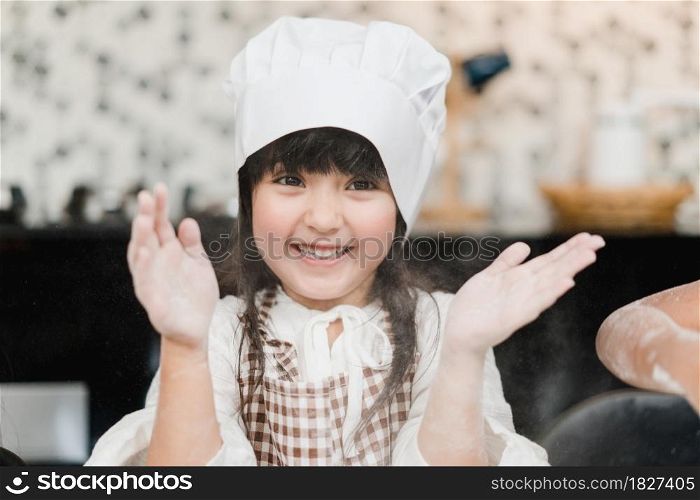 Group of children baking cake together in classroom, Multi-ethnic young boys and girls happy making dessert cooking in kitchen at school. Kids cooking at school concept.